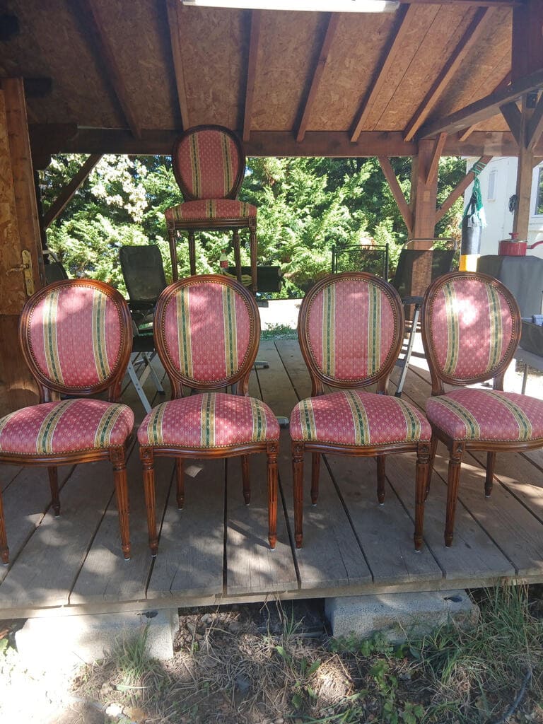 Golden yellow upholstered armchair with wooden frame and curved armrests fully restored, displayed in natural outdoor light in front of professional work van, showing pristine fabric and quality craftsmanship
