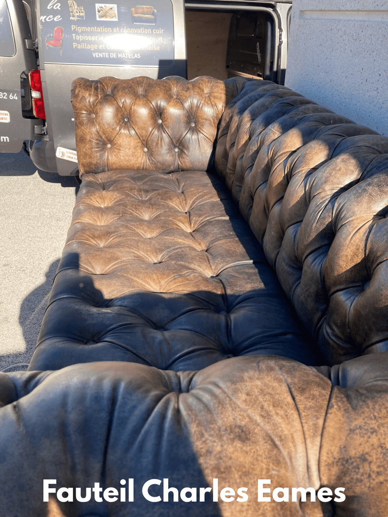 Golden yellow upholstered armchair with wooden frame and curved armrests fully restored, displayed in natural outdoor light in front of professional work van, showing pristine fabric and quality craftsmanship
